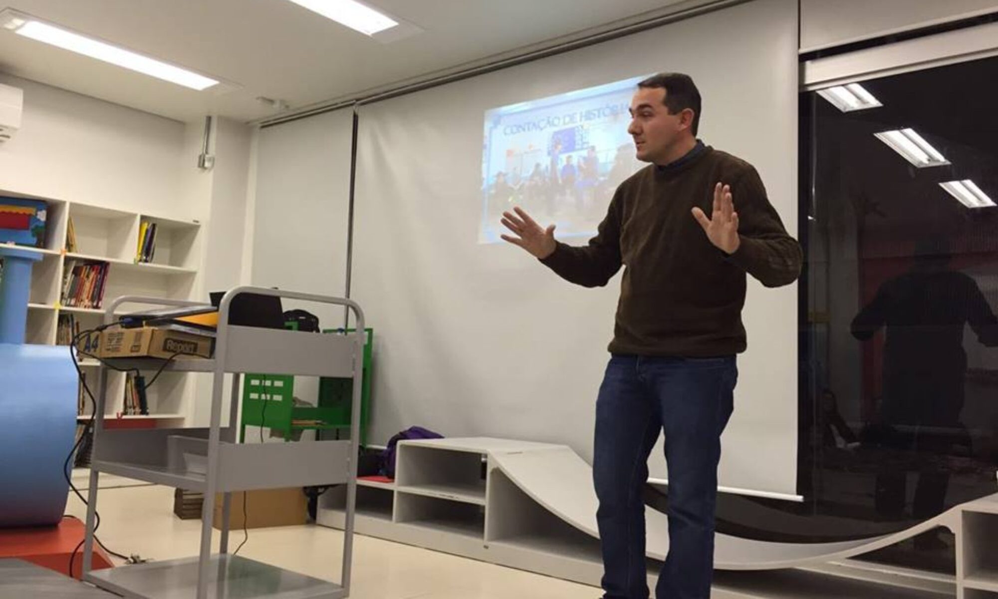 Carlos G. Steigleder durante uma apresentação em uma sala.
